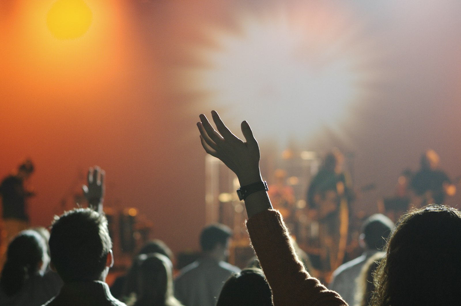 An evening worship gathering with people raising their hands